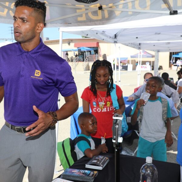 DTD staff talking to someone with three children listening in the background