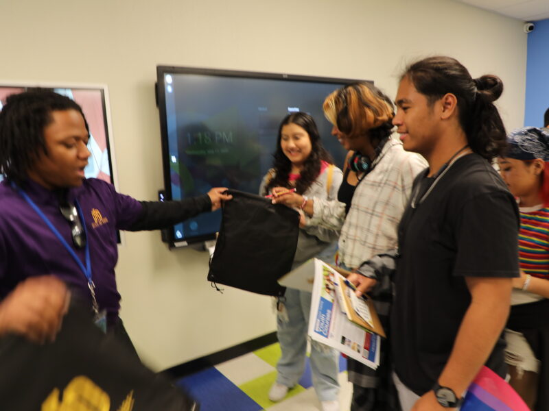 DTD staff giving bags to a group of students