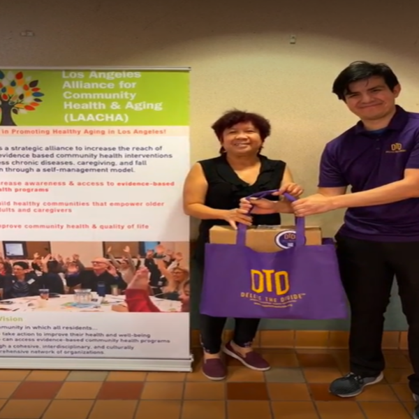 DTD intern holding a bag with a community member