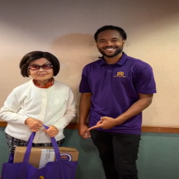 DTD intern pointing to a bag with a laptop that a person is holding on to