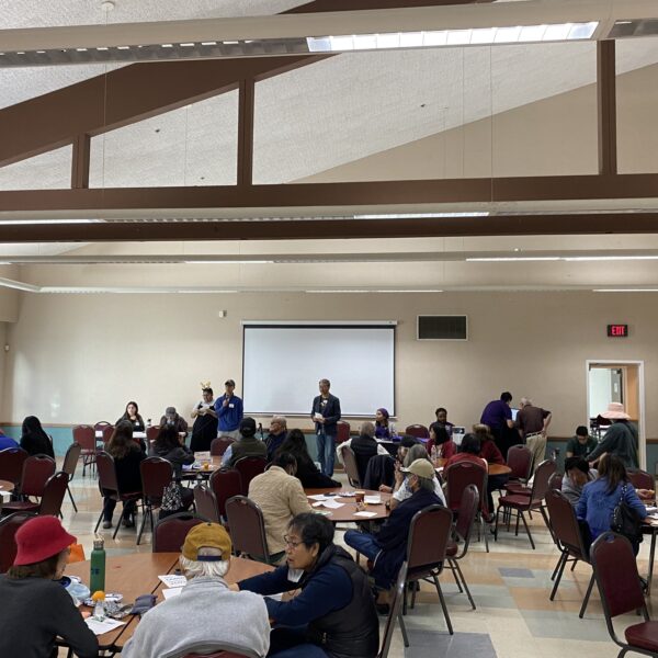 people of all ages sitting around round tables