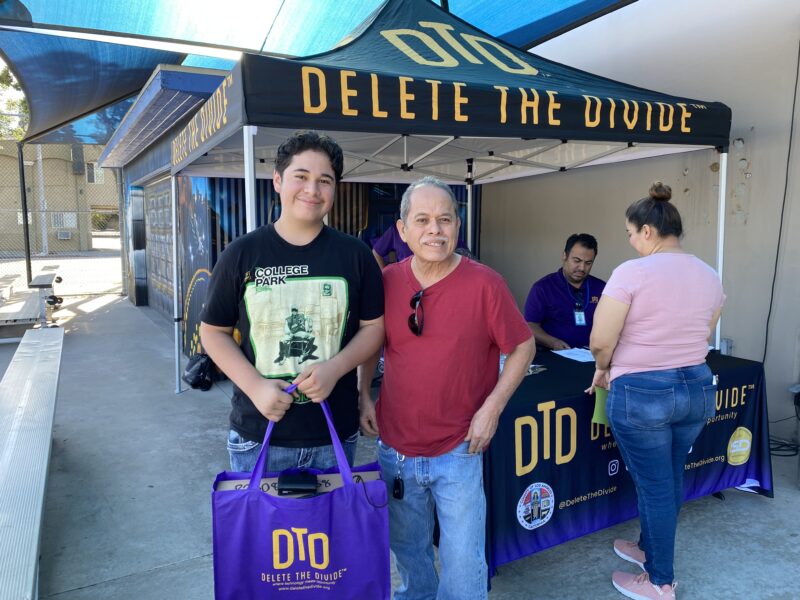 a father and son posing with DTD bag containing laptop