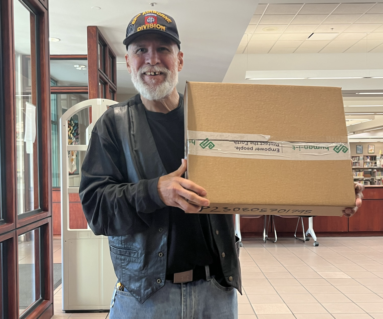 veteran holding up laptop