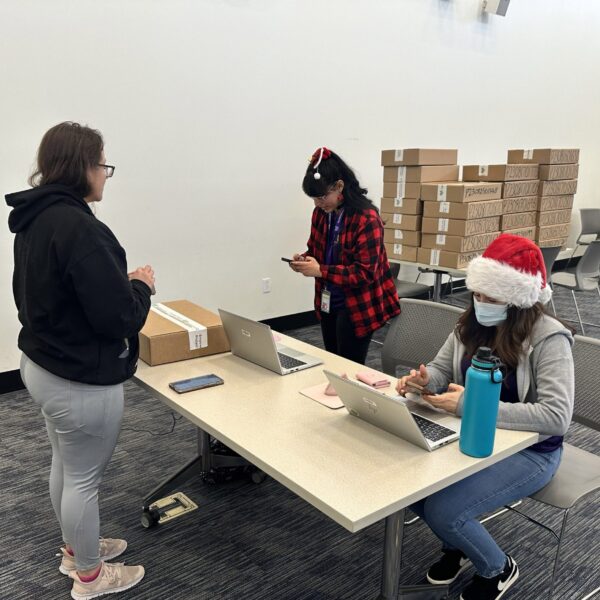 Interns on their computer helping a veteran receive their laptop