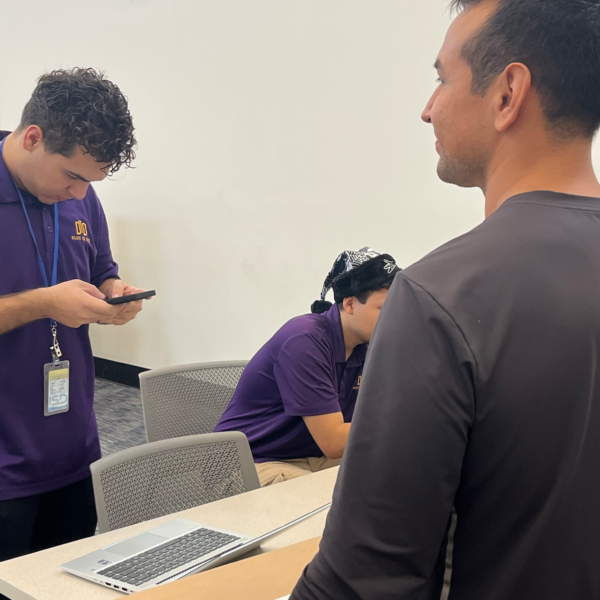 Intern on his phone helping people get their laptops