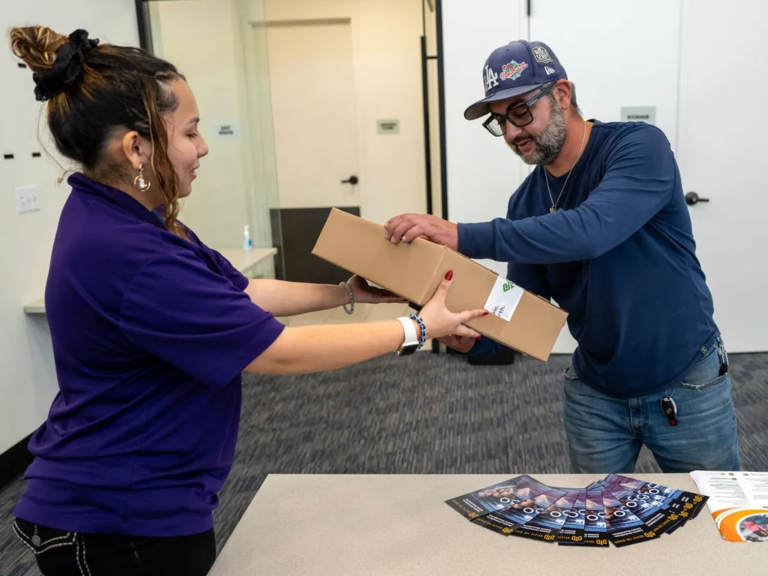Intern handing out Laptop to Veteran
