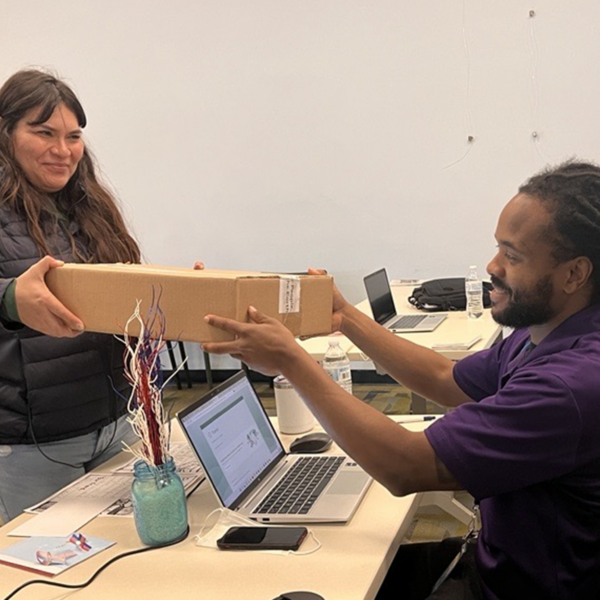 Intern handing out a Laptop box to a participant