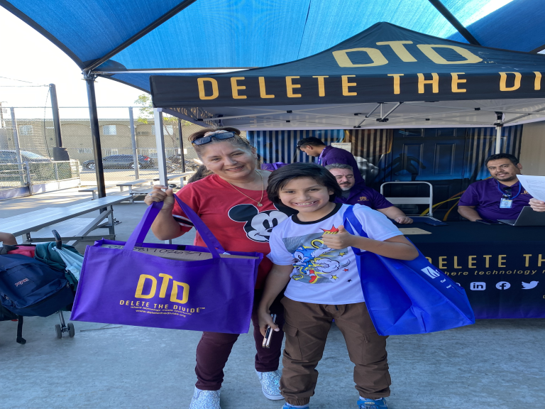 Smiling family with DTD merchandise and laptop.