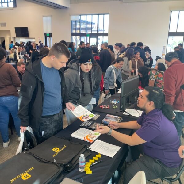 intern talking to students holding flyers