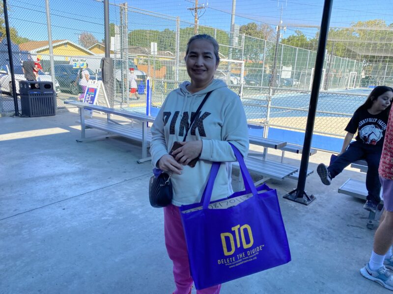 a community member holding a bag with a laptop