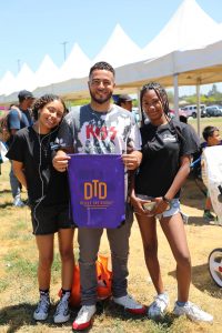 father with 2 daughters holding dtd bag