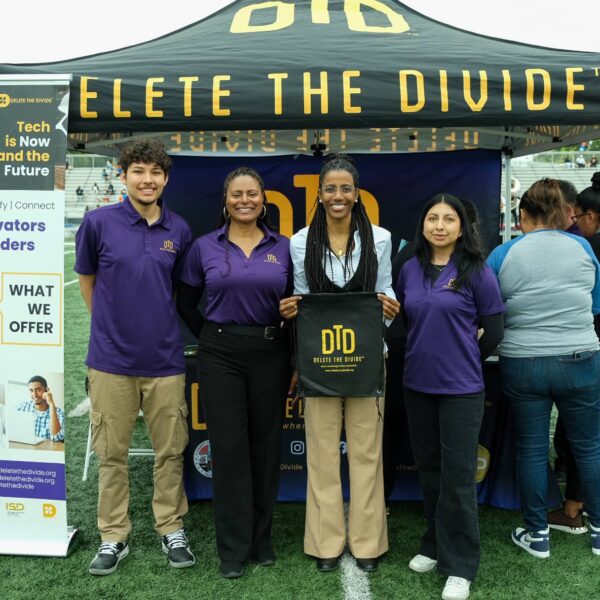 a group of people standing in front of the Delete The Divide booth
