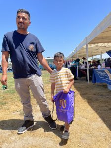 father and son holding dtd bag