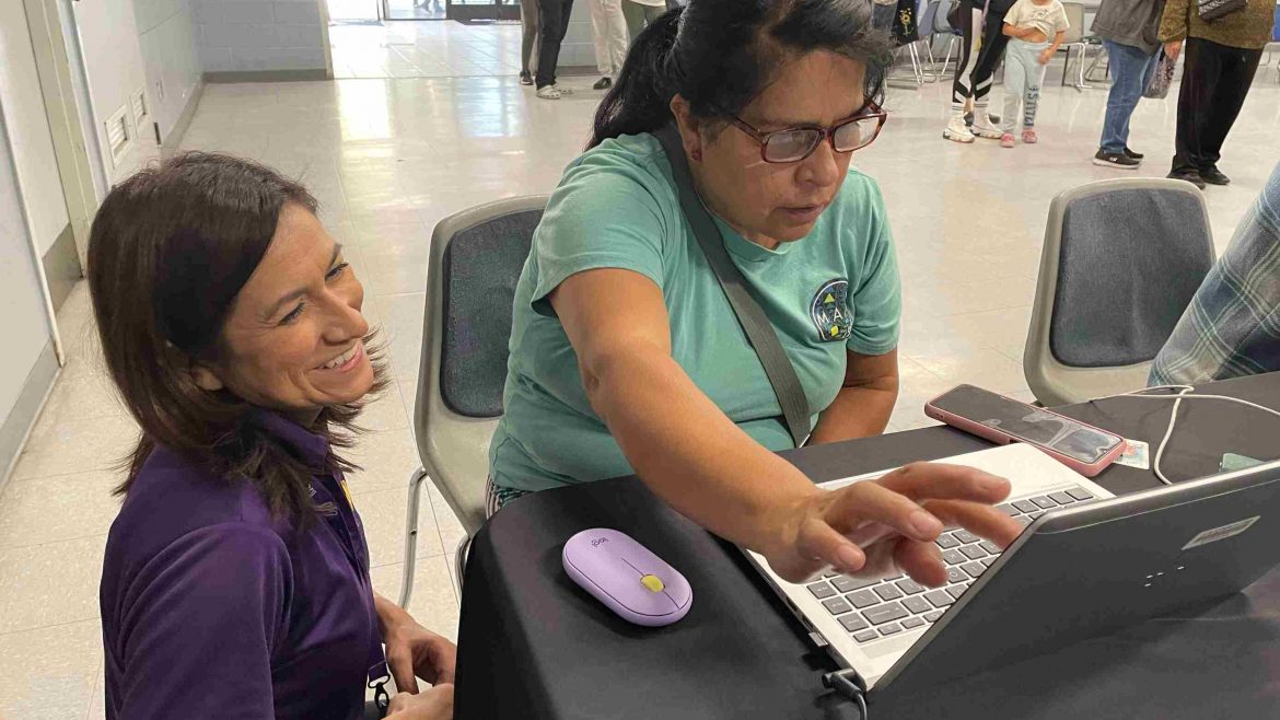 DTD staff helping participant as they are using a laptop
