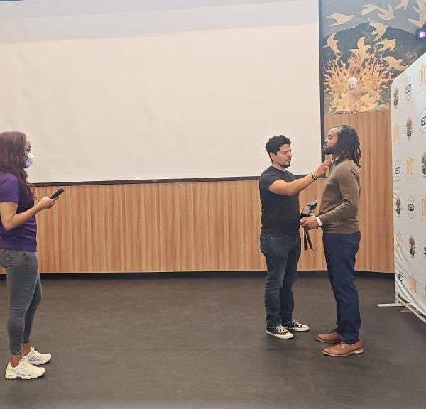 intern standing at photo station during cohort certification