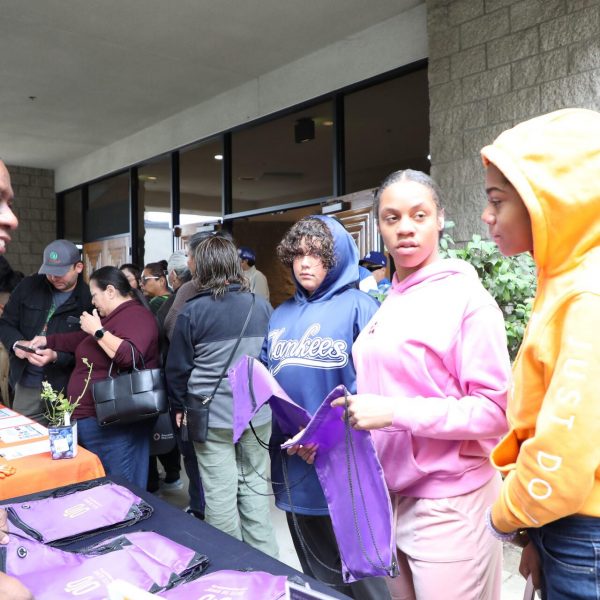 a group of children and adults talking to DTD staff