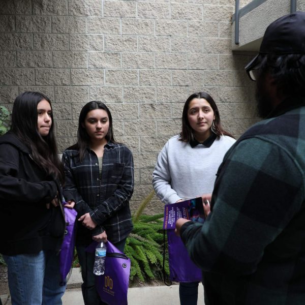 DTD staff handing out flyers to three girls