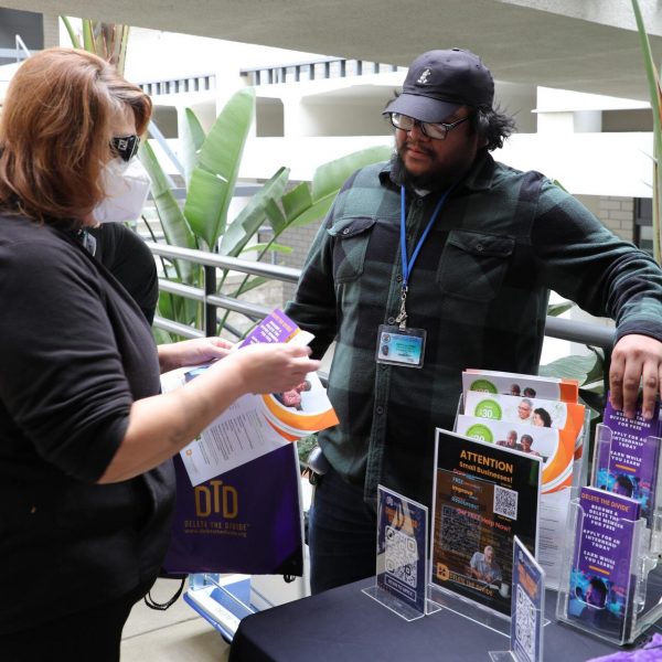 a person holding DTD flyers while talking to a DTD intern