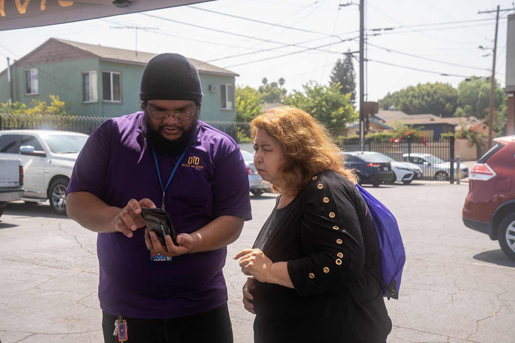 a DTD intern helping a woman with her phone