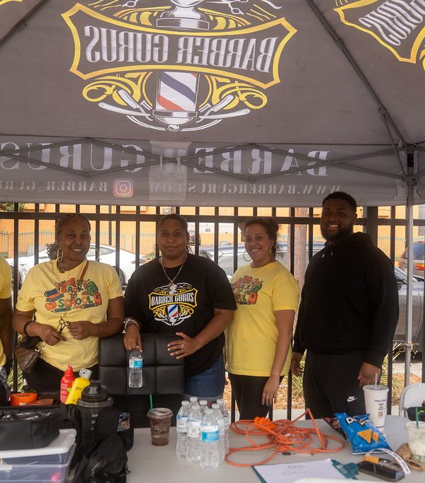 five people standing under a Barber Gurus canopy