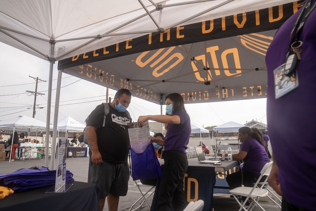 DTD intern putting flyer into bag while showing it to a person