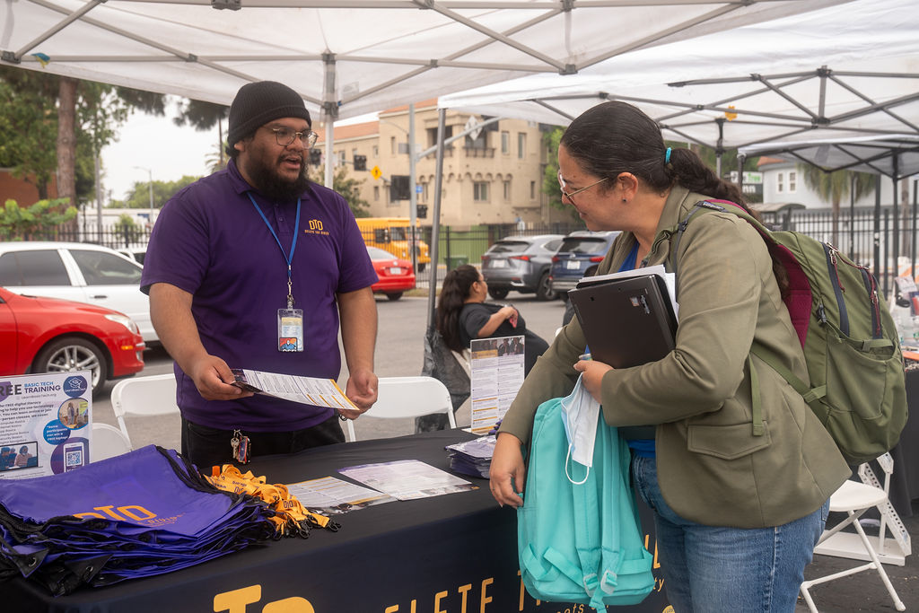 DTD intern handing out flyer and showing it to a person