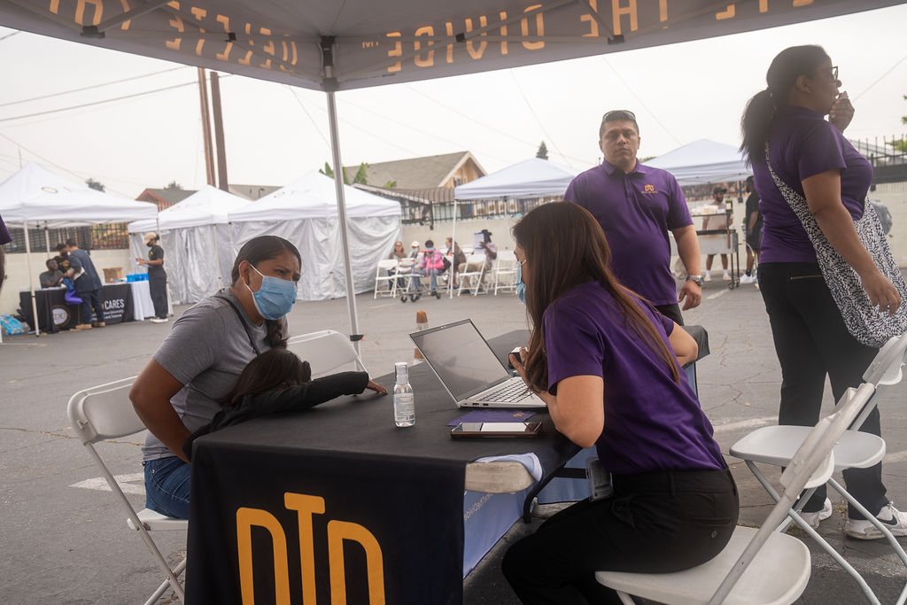 DTD staff using computer while trying to help someone