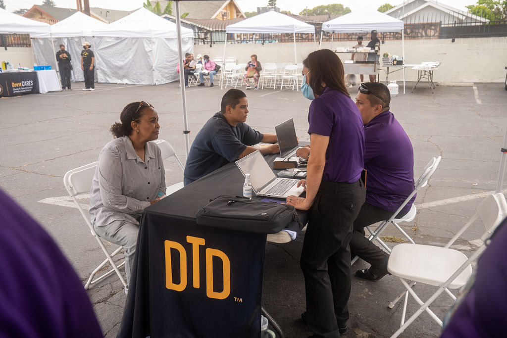 DTD staff helping two different people sitting at the table