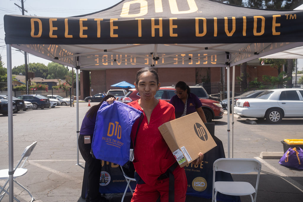 a woman holding a bag and a HP laptop box