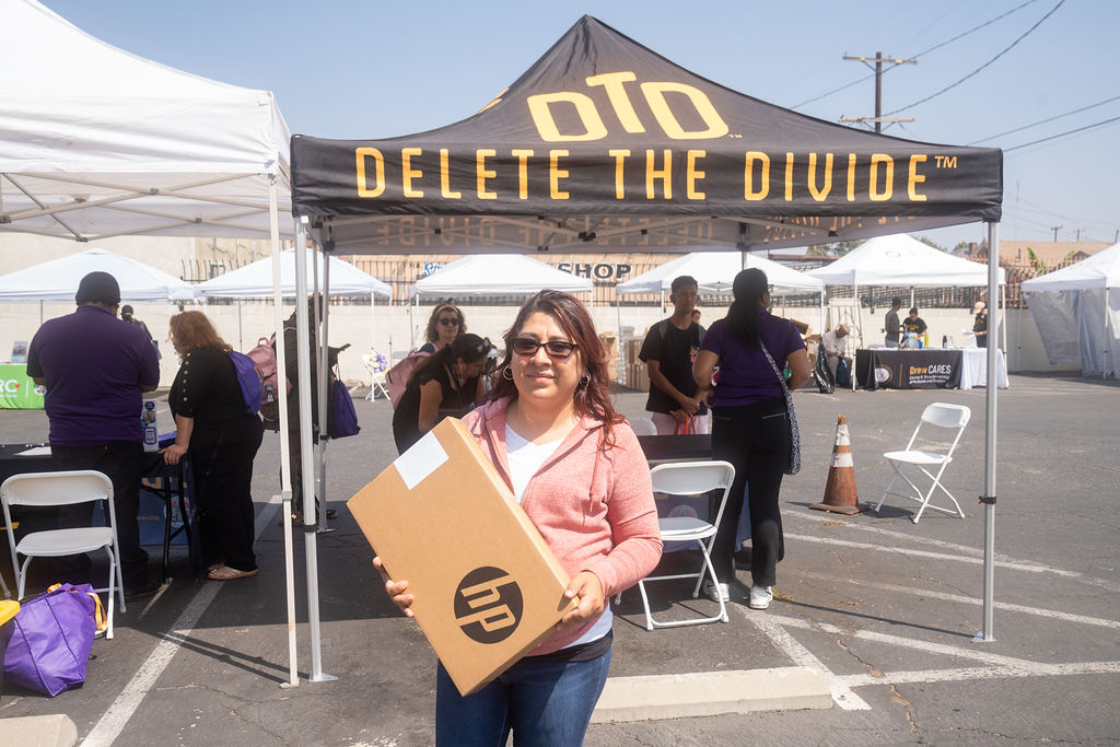 a woman holding a HP laptop box