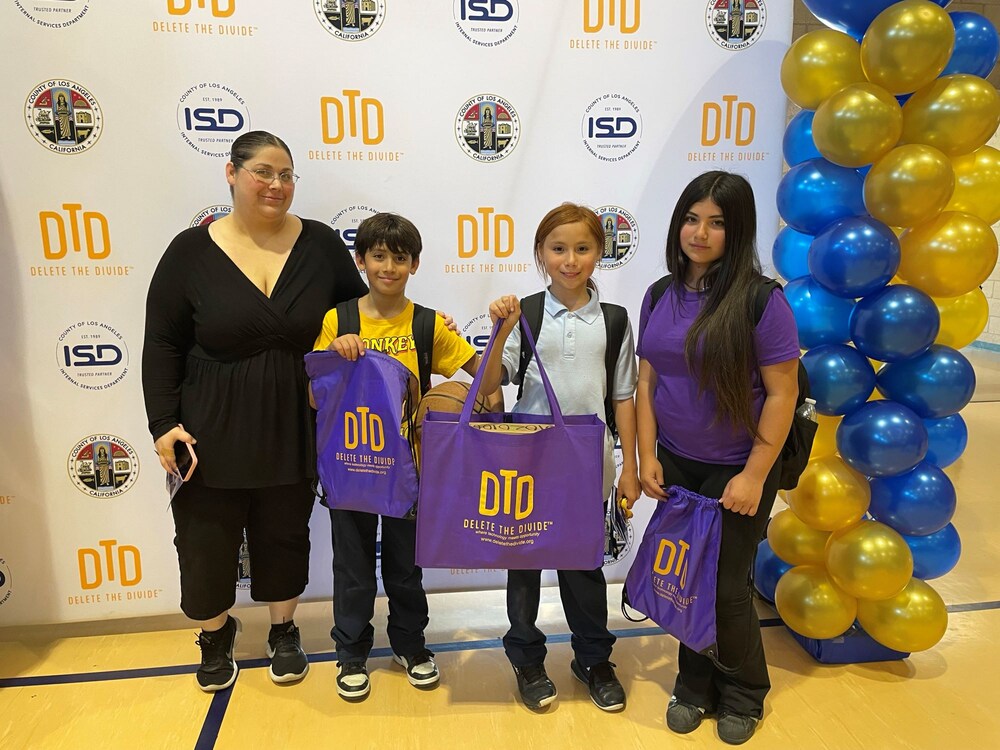 a family of four holding a bag with a laptop